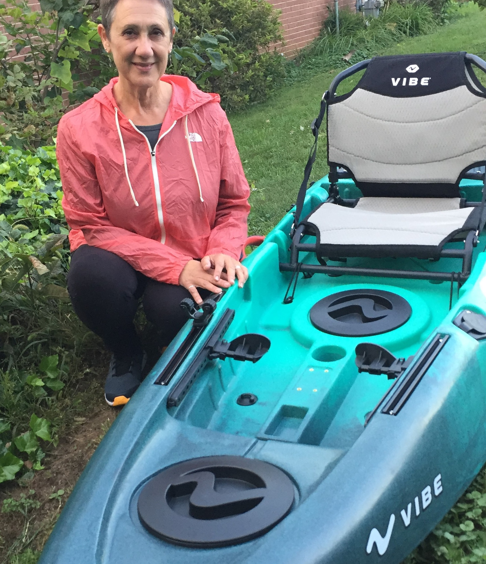 woman kneeling by kayak