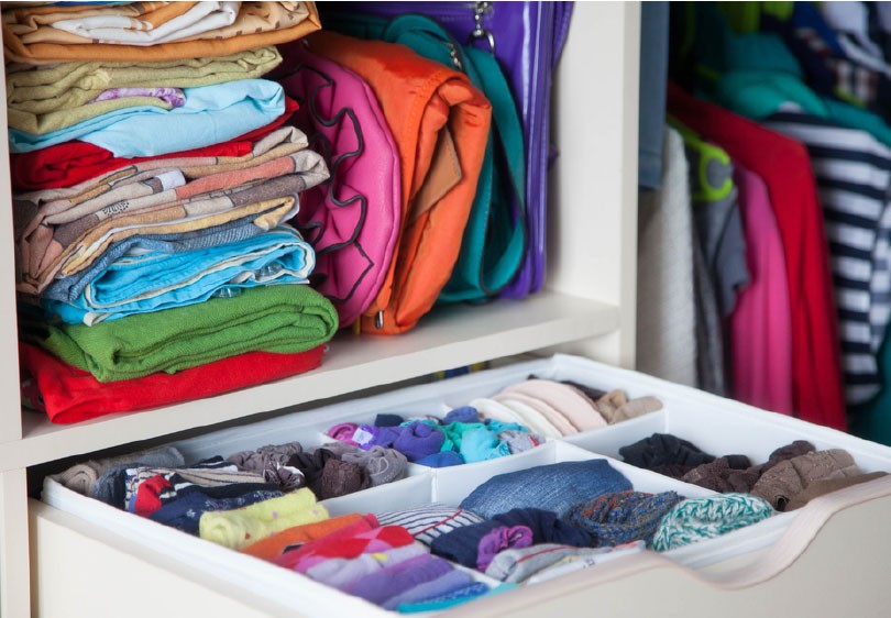 A picture of a very organized drawer and shelf.